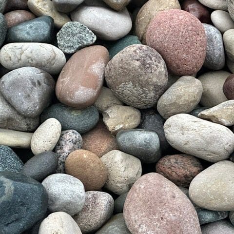 Smooth, multicolored pebbles closely packed together.